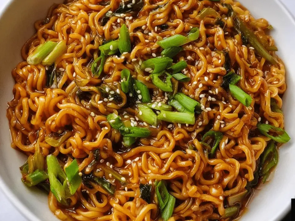 Skillet of garlic soy ramen stir-fry tossed with scallions and sesame seeds